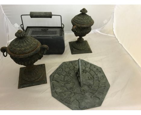 A pair of metal urns: sundial and heater box