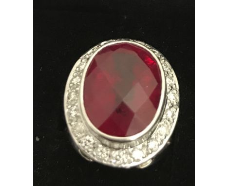 An 18ct ruby  and diamond dress ring, large central ruby with harlequin faceted cut