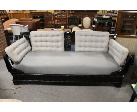 AN ART NOUVEAU EBONISED UPHOLSTERED SOFA WITH CUSHIONS