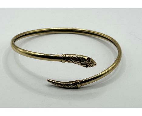 A 9ct gold snake bangle with garnet eyes, 8.6 g
