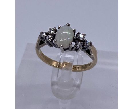 9ct Gold and Silver ladies ring, white opal centre stone with cluster of three diamonds to each side2.08gSize - K 