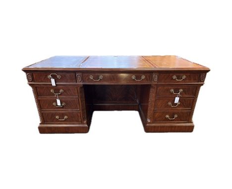 20th Century mahogany pedestal desk, the leather surface with carved moulded edging above three drawers with brass handles, f