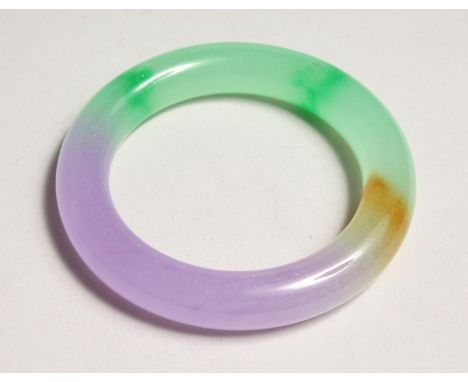 A MULTI COLOURED JADE BANGLE.