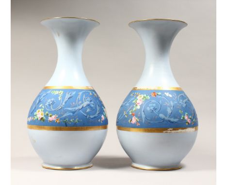 A LARGE PAIR OF CONTINENTAL LIGHT BLUE BULBOUS VASES, painted with a deep blue hand with flowers 15ins high.