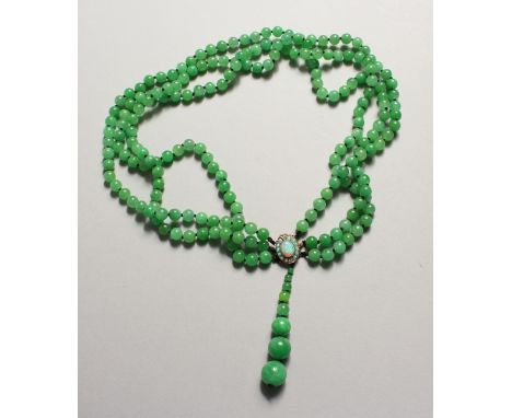 A TRIPLE ROW OF JADE BEADS with opal clasp