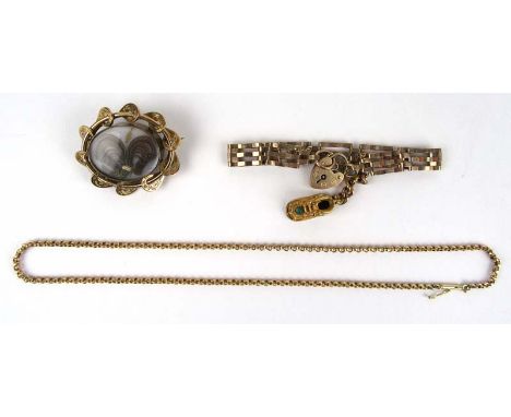 A Victorian yellow metal hairwork mourning brooch together with a 9ct gold gatelink bracelet, suspending one charm and a 9ct 