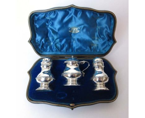 A cased silver three piece condiment set. Hallmarked for London, 1901. Makers mark for the Gold and Silversmiths Company ltd.