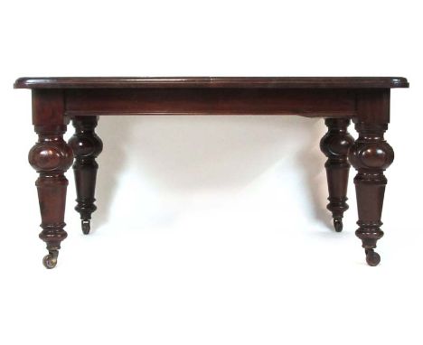 A Victorian mahogany extending dining table, the moulded top on turned and oval carved legs on ceramic castors, with three le