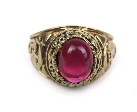 A 9ct yellow gold college ring with central cabochon ruby and engraved shoulders. Approx weight 5.6g CONDITION REPORT: Hallma