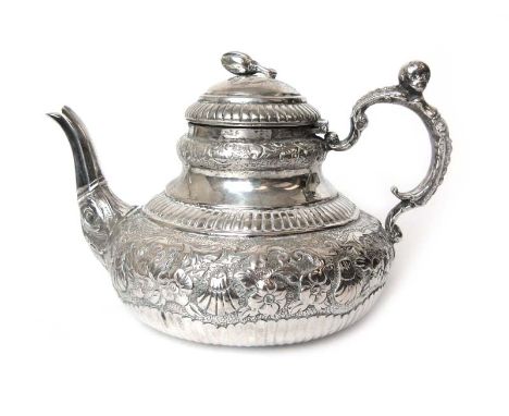 A white metal teapot of squat form with embossed naturalistic decoration. Approx weight 399g