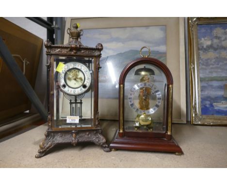 An ornate metal mantle clock with key and a wooden framed mantle clock with pendulum  