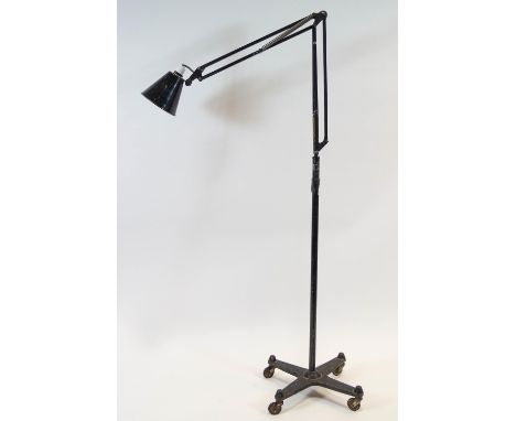 A floor standing angle poise lamp in black painted metal, on a pole stand set with a hook on a castered saltire base 189 cm h