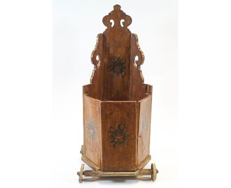A Swedish painted wood child's commode chair, with shaped and pierced back, painted with flowers on four wheels, 114cm high x