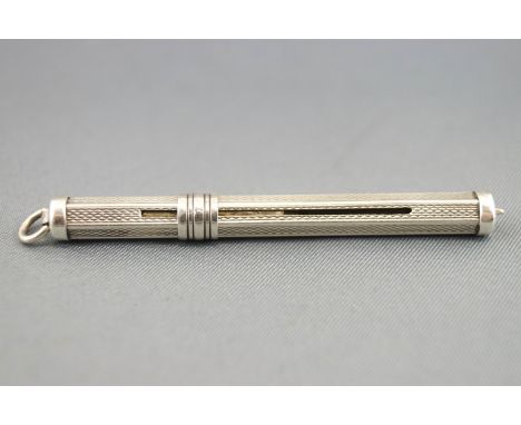 A silver toothpick, of hexagonal form, entirely decorated with engine turned decoration and set with a sliding mechanism, 5.5