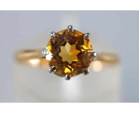 A yellow and white metal single stone ring set with a round faceted cut citrine quartz. Untested - stamped 18ct. Size: K 2.3 