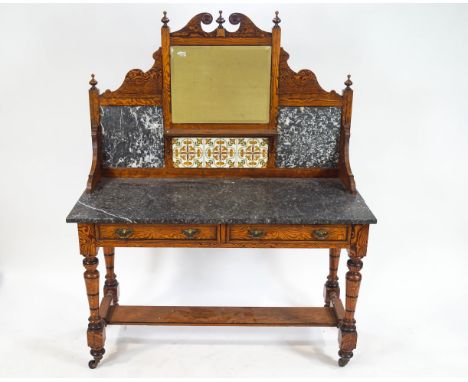 A 19th century pitch pine washstand with decorative shaped back with broken pediment above a square mirror and tile motif and