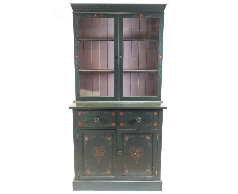 A painted bookcase, the glazed double doors enclosing two shelves above a base with two short drawers and two panelled cupboa