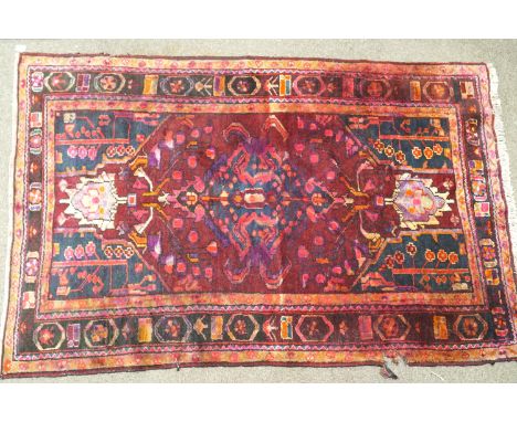 A handmade Persian Lori carpet, circa 1930-1950, with a central lozenge on a dark ground, decorated with foliates in natural 