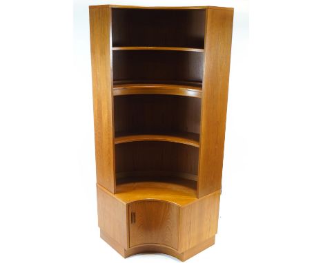 A G-plan teak convex corner cupboard, with three shelves above a cupboard, the middle shelf with electrified lighting 199 cm 