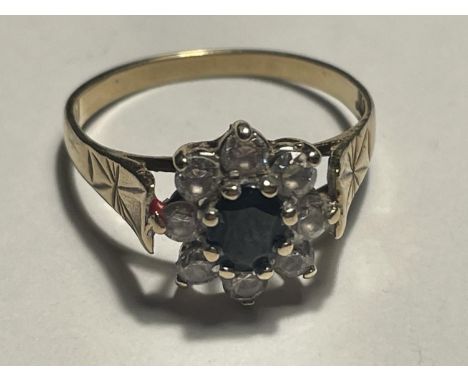 A 9 CARAT GOLD RING WITH A CENTRE SAPPHIRE SURROUNDED BY EIGHT CUBIC ZIRCONIAS SIZE M 