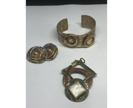 BRASS AND COPPER ARTS AND CRAFTS STYLE JEWELLERY TO INCLUDE A BANGLE, PENDANT AND A PAIR OF CLIP ON EARRINGS 
