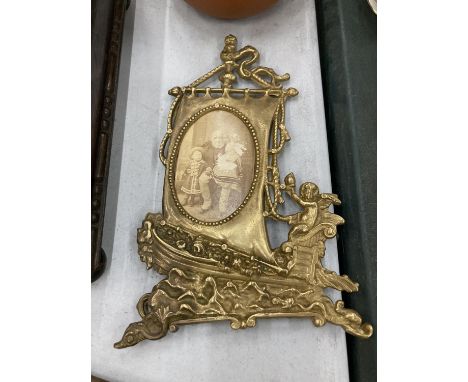 A VINTAGE BRASS PHOTO FRAME SHAPED AS A BOAT 