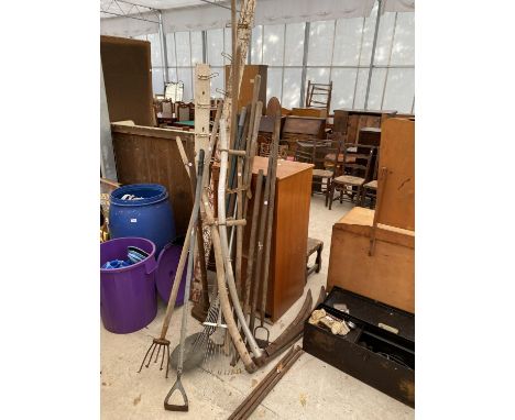 AN ASSORTMENT OF GARDEN TOOLS TO INCLUDE SYTHES, RAKES AND HOES ETC 