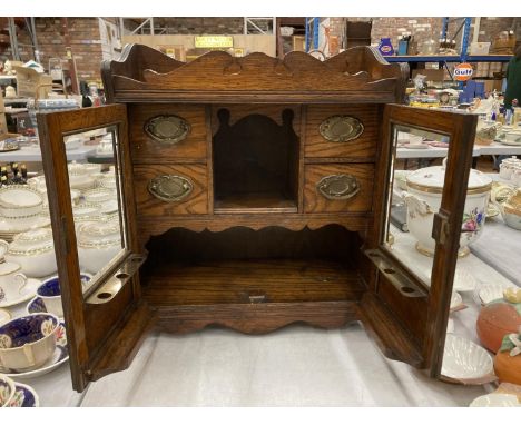 A VINTAGE OAK SMOKERS CABINET WITH BEVELLED GLASS DOORS, BRASS HANDLED DRAWERS, GALLERIED TOP, ETC HEIGHT 46CM, WIDTH 41CM , 