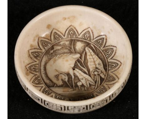 A well carved Chinese miniature ivory bowl, the central panel carved with a waterbird amongst lilies, a carved key fret borde