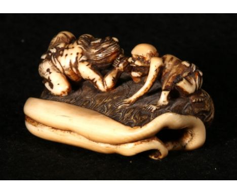 Japanese Meiji ivory netsuke depicting an oni and a lohan wrestling on a giant lotus leaf, the oni holding on to the leaf sta