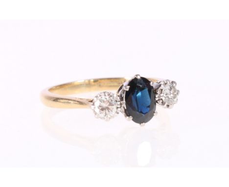 18ct gold sapphire and diamond three-stone ring, the central oval cut sapphire flanked by round brilliant cut diamond measuri