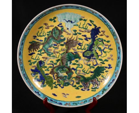 Late 19th Chinese yellow ground dish, decorated with lion dogs, amongst clouds with cloud and flaming pearl decorative rim, s