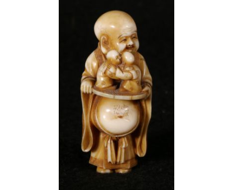 Japanese ivory netsuke depicting Hotei with an extended stomach upon which he balances a fan with two miniature wrestlers, si