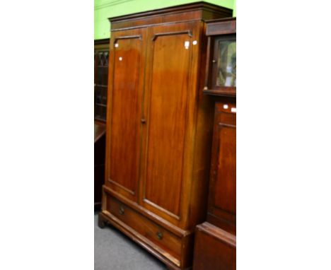 A mahogany double wardrobe fitted with a base drawer 