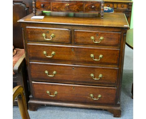 A George III oak four height chest of drawers, two short above three long drawers flanked by quarter columns, on bracket feet