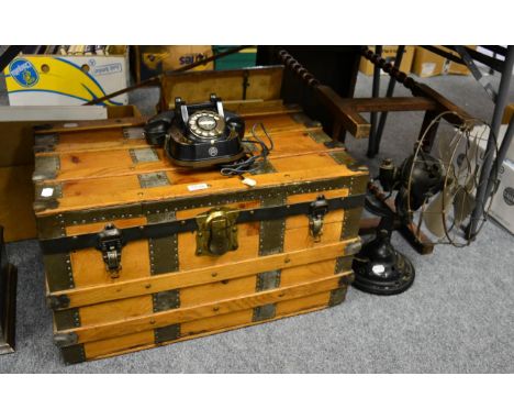 A retro fan, a rotary dial telephone and a metal bound wooden trunk