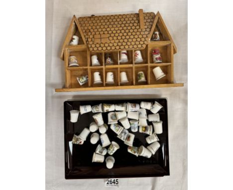 A quantity of porcelain thimbles &amp; a small display shelf