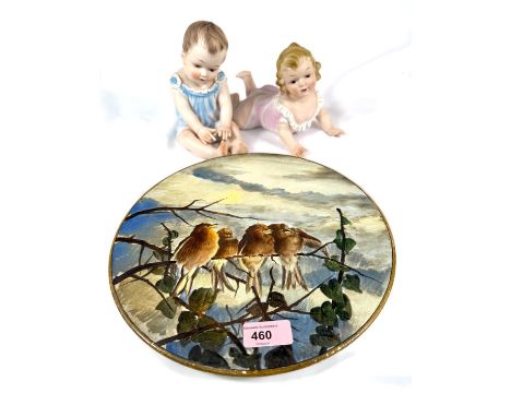 A 19th Century circular wall plaque with birds, "Winter" by A. Millis, diameter 29cm; a pair of bisque piano babies.