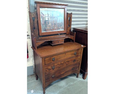 An oak Arts and Crafts dressing chest with mirror back and three drawers bellow