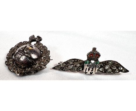 A silver RAF badge with clear stone studded wings and a similar maritime badge with globe and lion.