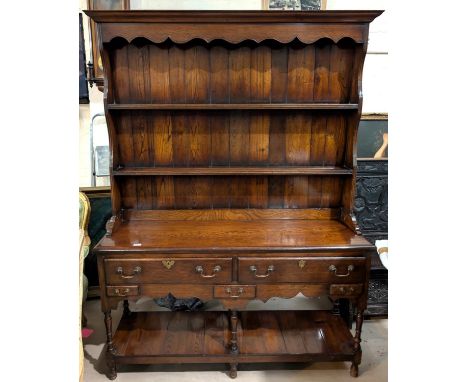 A reproduction oak Titmarch and Goodwin style traditional Welsh Dresser with two long and two short drawers, two height back 