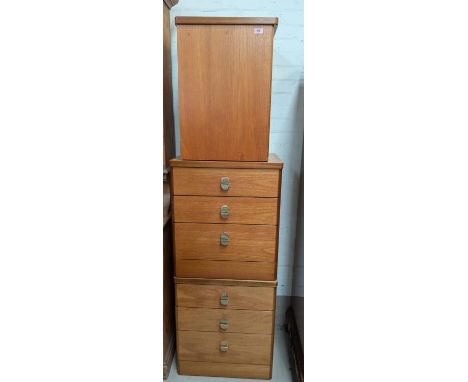 A pair of Stag teak three-height chests of drawers and a similar item.