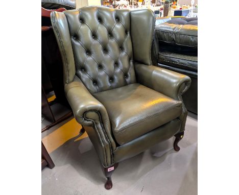 An antique green wing back Chesterfield deeply button back arm chair with stool