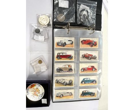 USA 1921 silver dollar, various other coins and medals, Kew 50p and 1933 1d fakes, an album of cigarette cards.