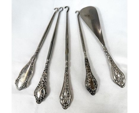 A selection of four silver handle button hooks and a shoe horn, Chester hallmarks.