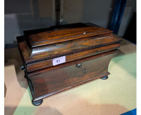 A Georgian Rosewood sarcophagus tea caddy, waisted body, stepped lid, interior glass bowl.