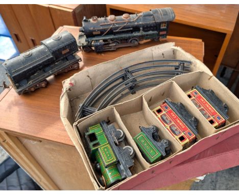 A Brimtoy tin plate boxed train set; an 'O' gauge Lionel Corporation train and another.