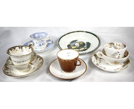 An early Rockingham style trio set in grey and gilt, comprising a tea cup, coffee cup and saucer; a similar set of two other 