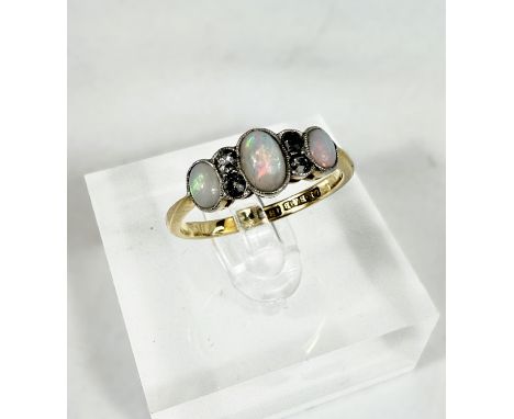 A yellow metal dress ring set with 3 opals interspersed with 4 diamond chips, stamped 18ct, 2.4gms, size O-P Condition report
