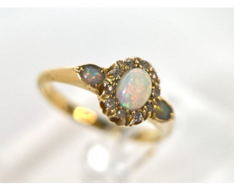 A 18ct hallmarked gold dress ring set with a central opal surrounded by diamonds and an opal to each shoulder, 3.4gms, size N